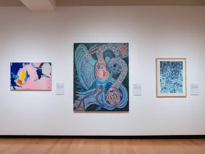 Three abstract paintings on a white wall