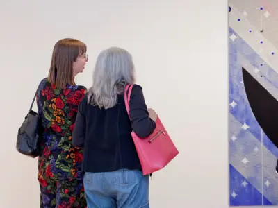 Two women looking at a painting