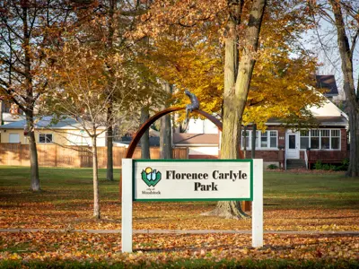 Florence Carlyle Park sign with Wind Vane sculpture in the background